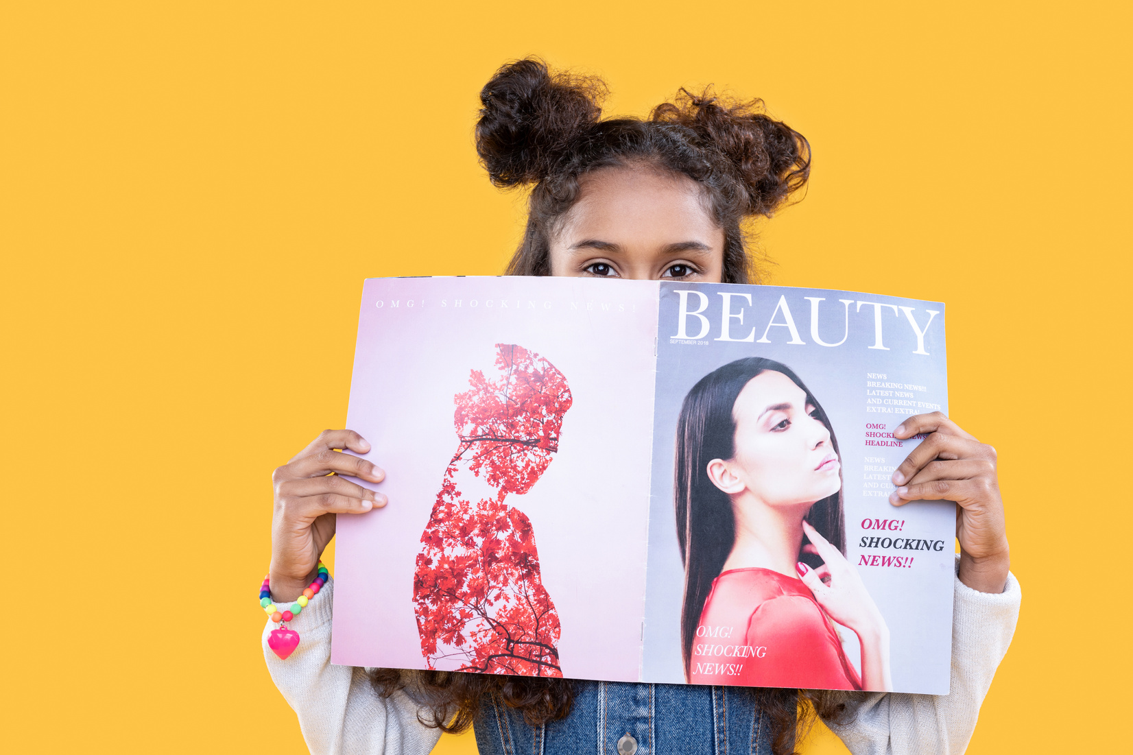 Nice pleasant girl holding a beauty magazine